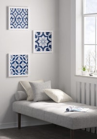 three blue and white framed pictures in a room