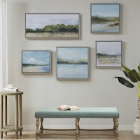 four framed paintings on the wall of a living room