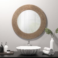 a bathroom with a round mirror and a sink