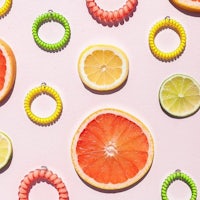 a bunch of citrus fruits arranged on a pink background